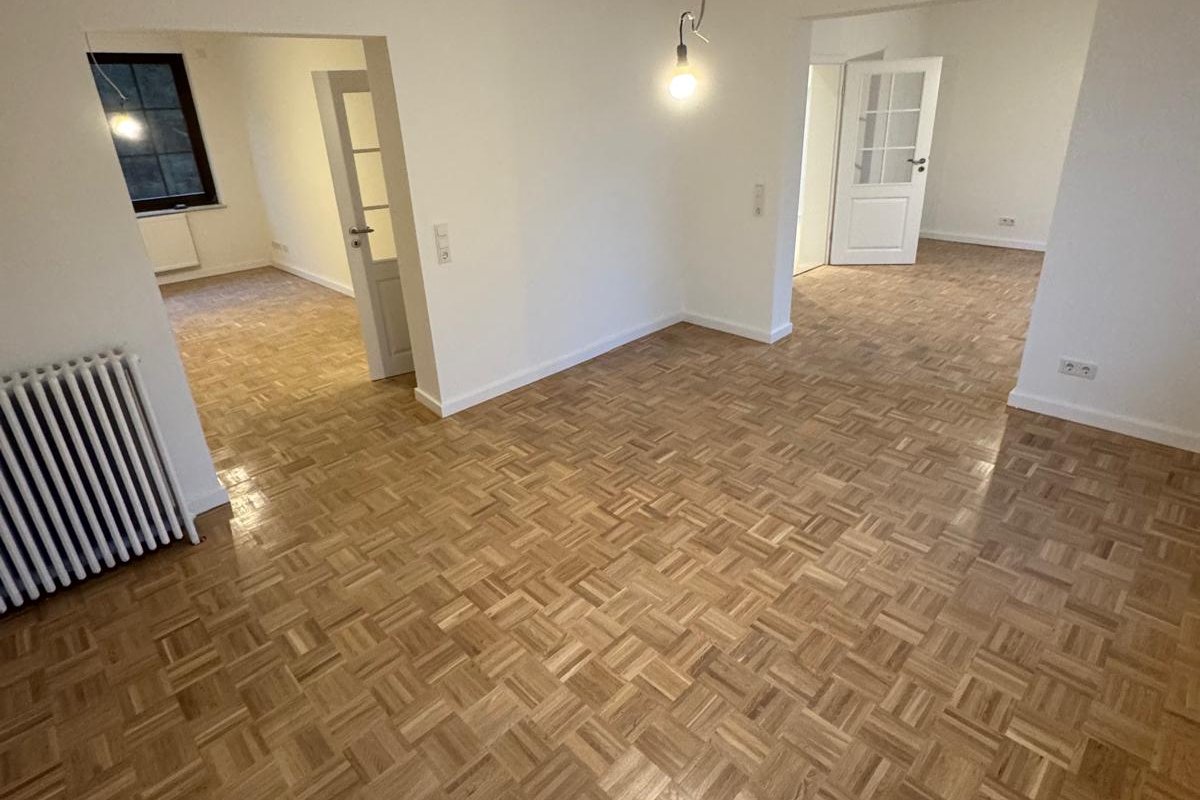 Altbauwohnung mit hellem, neu verlegtem Parkett in Würfelverlegung.