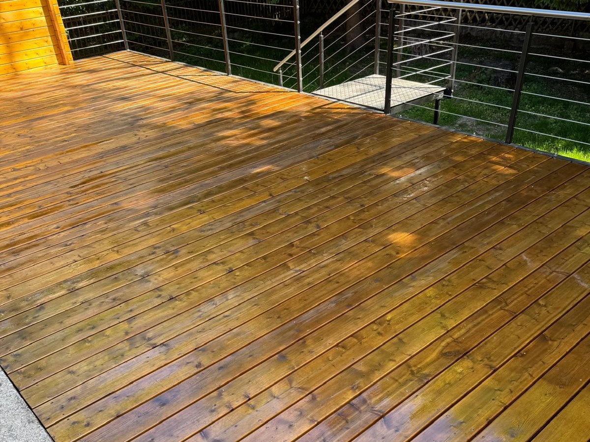 Dieselbe Terrasse nach dem Anstrich, die Dielen sind warm nachgedunkelt.